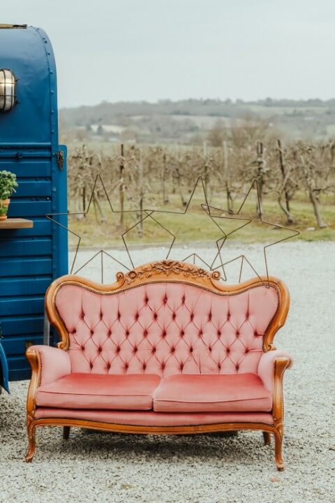 A sofa decorated with stars set up next to the Vintage Horse Box Tipsy